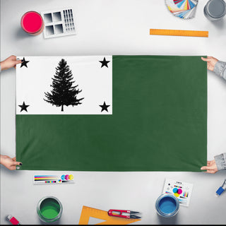 A mockup of the custom flag 'pine tree flag' held up on a table during print checking