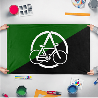 A mockup of the custom flag 'Anarcho Cyclist flag' held up on a table during print checking