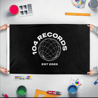 A mockup of the custom flag '104 records flag' held up on a table during print checking