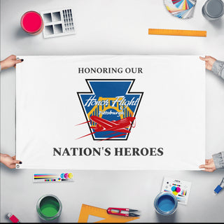 A mockup of the custom flag 'HFP-White-HONH flag' held up on a table during print checking