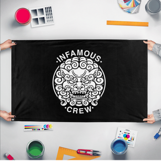 A mockup of the custom flag 'Infamous crew flag' held up on a table during print checking