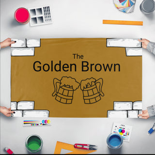 A mockup of the custom flag 'The golden brown flag' held up on a table during print checking
