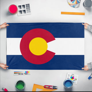 A mockup of the custom flag 'Colorado State Flag' held up on a table during print checking