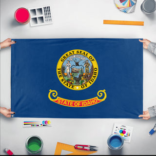 A mockup of the custom flag 'Idaho State Flag' held up on a table during print checking
