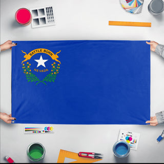 A mockup of the custom flag 'Nevada State Flag' held up on a table during print checking