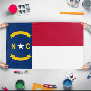 A mockup of the custom flag 'North Carolina State Flag' held up on a table during print checking