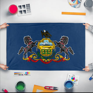 A mockup of the custom flag 'Pennsylvania State Flag' held up on a table during print checking