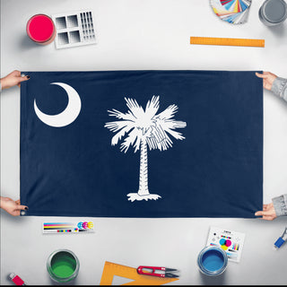 A mockup of the custom flag 'South Carolina State Flag' held up on a table during print checking