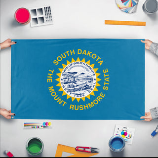 A mockup of the custom flag 'South Dakota State Flag' held up on a table during print checking