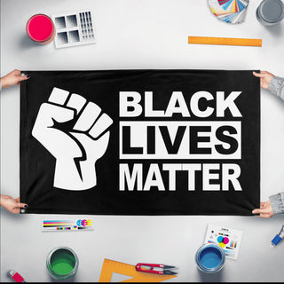 A mockup of the custom flag 'Black Lives Matter Flag' held up on a table during print checking