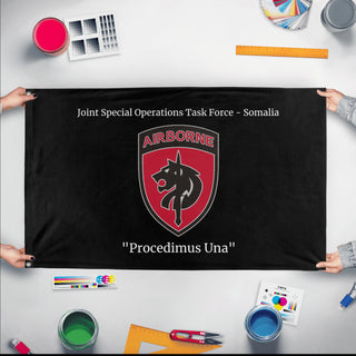 A mockup of the custom flag 'SOCAF 2 flag' held up on a table during print checking