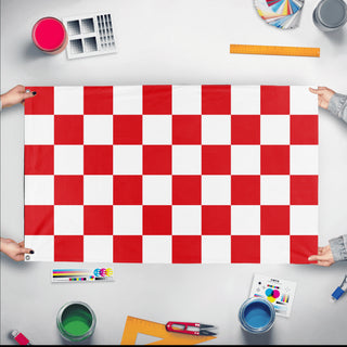 A mockup of the custom flag 'Red and White Checkered Flag' held up on a table during print checking
