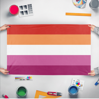 A mockup of the custom flag 'Orange Lesbian Flag' held up on a table during print checking