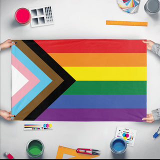 A mockup of the custom flag 'Progress Flag' held up on a table during print checking