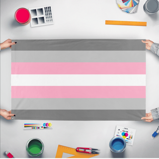 A mockup of the custom flag 'Demigirl Flag' held up on a table during print checking