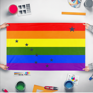 A mockup of the custom flag 'Alaska Pride Flag' held up on a table during print checking