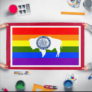 A mockup of the custom flag 'Wyoming Pride Flag' held up on a table during print checking