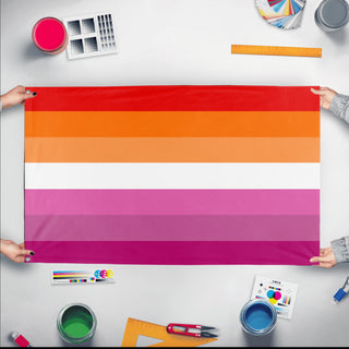 A mockup of the custom flag 'lesbian flag orange flag' held up on a table during print checking