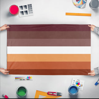 A mockup of the custom flag 'stud lesbian flag' held up on a table during print checking