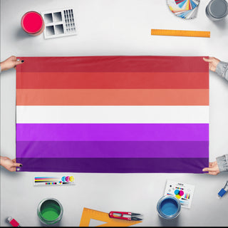 A mockup of the custom flag 'ace lesbian flag' held up on a table during print checking