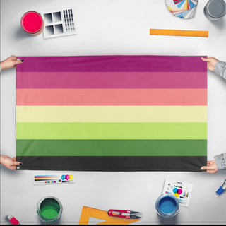 A mockup of the custom flag 'aromantic lesbian flag' held up on a table during print checking