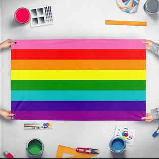 A mockup of the custom flag 'Original 8 Stripe Gilbert Baker Rainbow Pride Flag' held up on a table during print checking