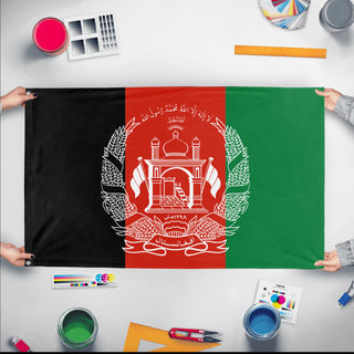 A mockup of the custom flag 'Flag of Afghanistan flag' held up on a table during print checking