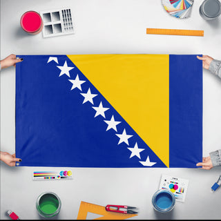 A mockup of the custom flag 'Flag of Bosnia and Herzegovina flag' held up on a table during print checking