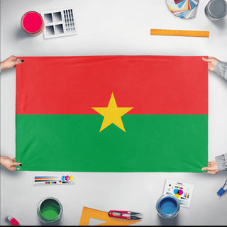 A mockup of the custom flag 'Flag of Burkina Faso flag' held up on a table during print checking