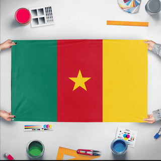 A mockup of the custom flag 'Flag of Cameroon flag' held up on a table during print checking