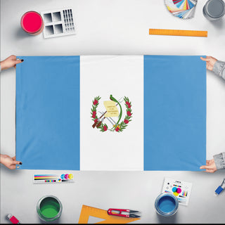 A mockup of the custom flag 'Flag of Guatemala flag' held up on a table during print checking