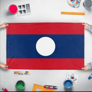 A mockup of the custom flag 'Flag of Laos flag' held up on a table during print checking