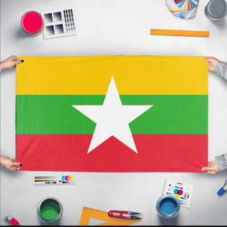 A mockup of the custom flag 'Flag of Myanmar flag' held up on a table during print checking