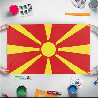 A mockup of the custom flag 'Flag of North Macedonia flag' held up on a table during print checking