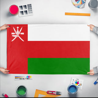 A mockup of the custom flag 'Flag of Oman flag' held up on a table during print checking