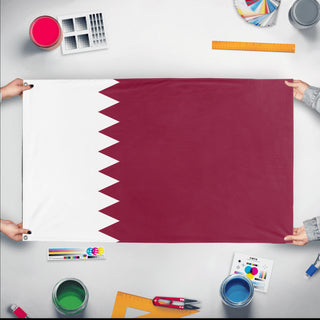 A mockup of the custom flag 'Flag of Qatar flag' held up on a table during print checking