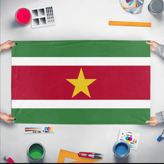 A mockup of the custom flag 'Flag of Suriname flag' held up on a table during print checking