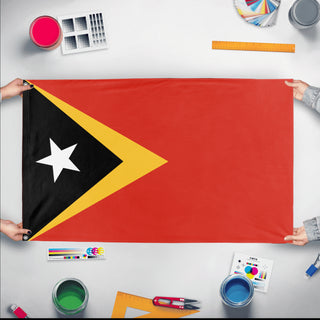 A mockup of the custom flag 'Flag of Timor-Leste flag' held up on a table during print checking