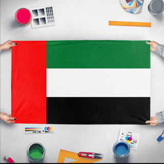 A mockup of the custom flag 'Flag of United Arab Emirates flag' held up on a table during print checking