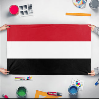 A mockup of the custom flag 'Flag of Yemen flag' held up on a table during print checking