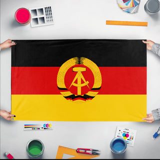 A mockup of the custom flag 'Socialist Germany Flag' held up on a table during print checking