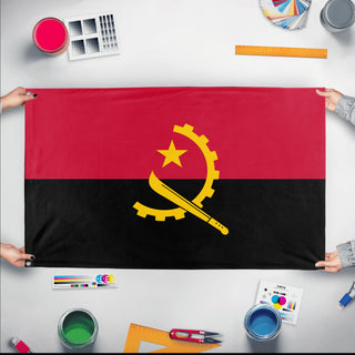 A mockup of the custom flag 'Socialist Angola Flag' held up on a table during print checking