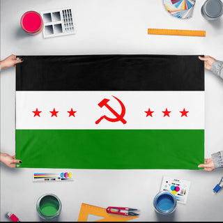 A mockup of the custom flag 'Socialist Syria Flag' held up on a table during print checking