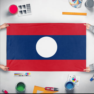 A mockup of the custom flag 'Socialist Laos Flag' held up on a table during print checking
