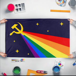 A mockup of the custom flag 'Luxury Gay Space Communism Flag' held up on a table during print checking