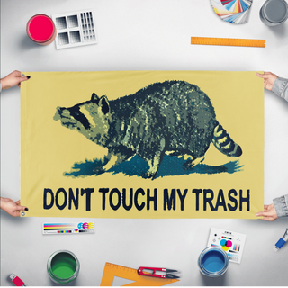 A mockup of the custom flag 'Don't Touch My Trash Flag' held up on a table during print checking