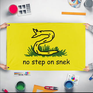A mockup of the custom flag 'No Step on Snek flag' held up on a table during print checking