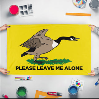 A mockup of the custom flag 'Please Leave me Alone Gadsden Flag' held up on a table during print checking
