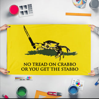 A mockup of the custom flag 'Crab Gadsden Flag' held up on a table during print checking