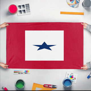 A mockup of the custom flag 'Flag in support of active duty flag' held up on a table during print checking